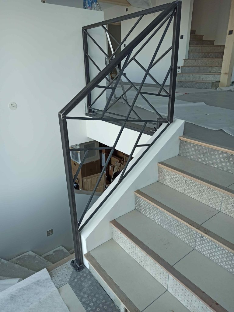 Garde-corps rampant en acier suivant la pente de l’escalier et son palier.