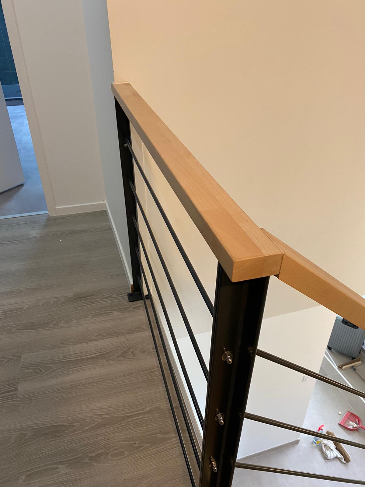 Détail de la main courante en bois et de son raccord entre le palier et la montée.
