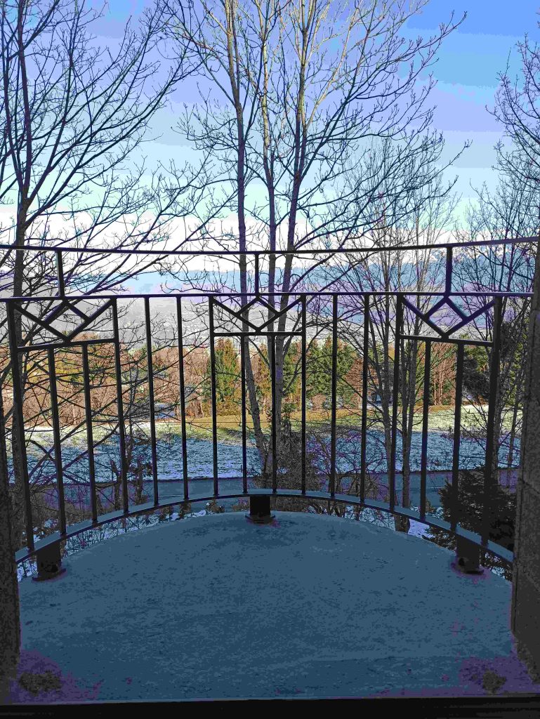 Vue de face du garde-corps courbe du balcon et de ses fixations au sol.