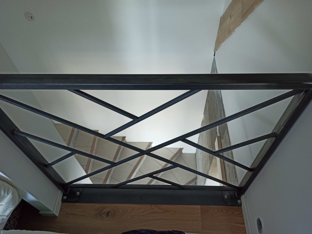 Détail des lignes croisées et des assemblages du garde-corps intérieur au-dessus de l’escalier.