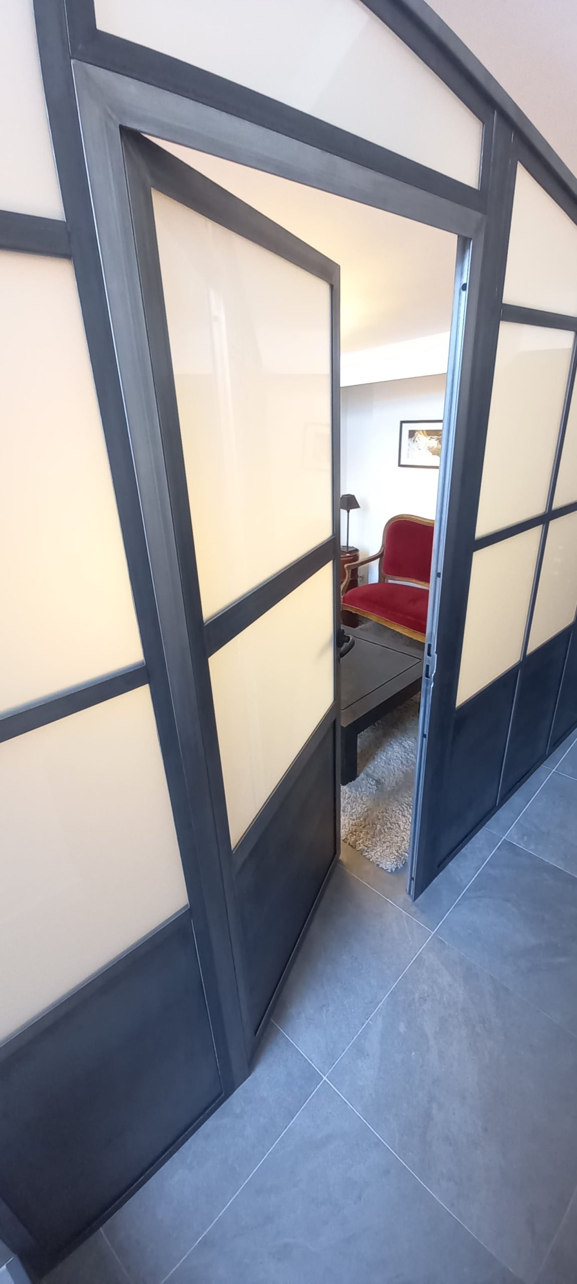Porte battante entrouverte donnant accès à la chambre créée dans l’appartement.